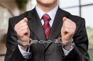 Suited person in handcuffs