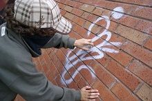 Person putting graffiti on a brick wall