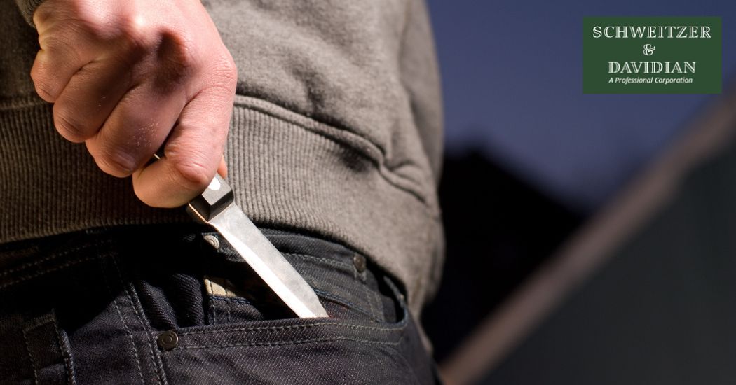 man hiding a knife in his pocket