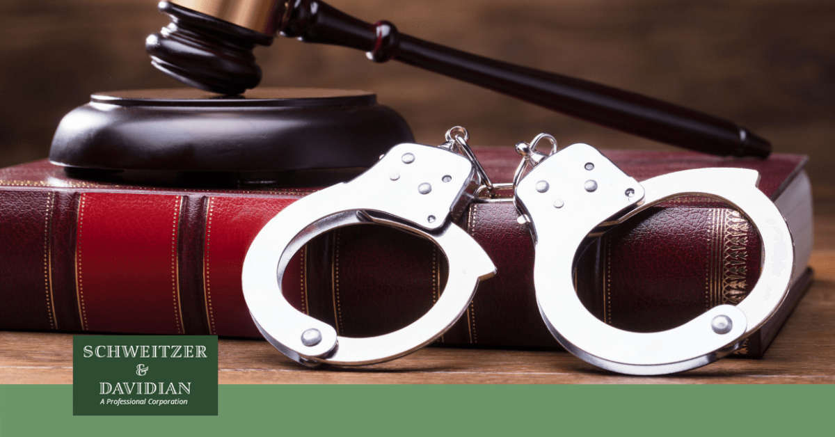 handcuffs resting on books holding gavel