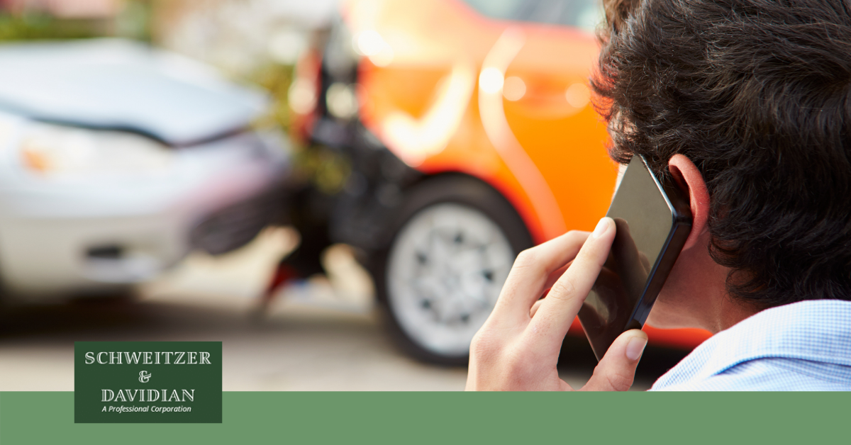person on phone looking at car accident scene