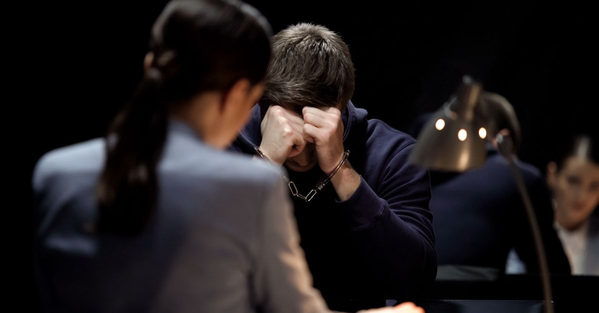 Upset man in handcuffs in interrogation