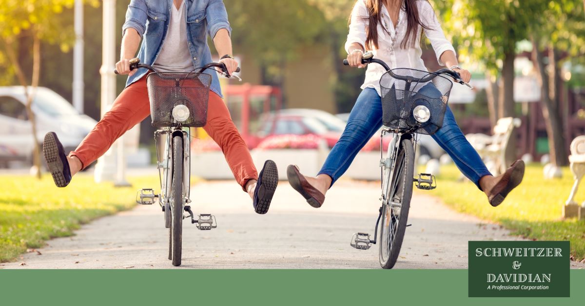 two people on bicycles with feet off pedals
