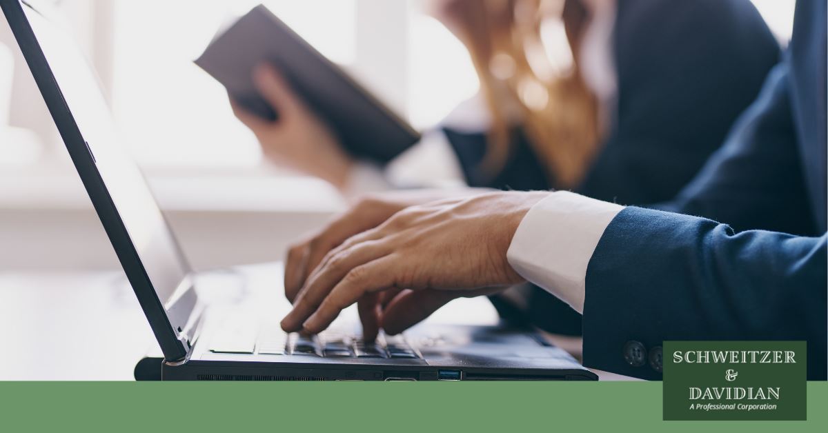 man in a suit typing on laptop