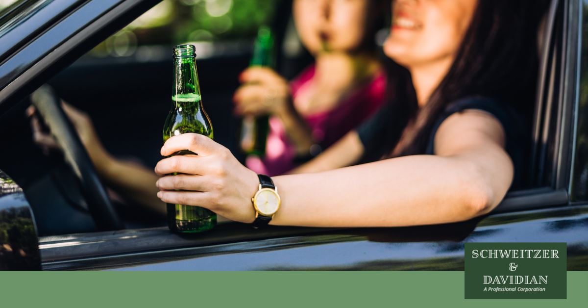 young woman driver holding a beer