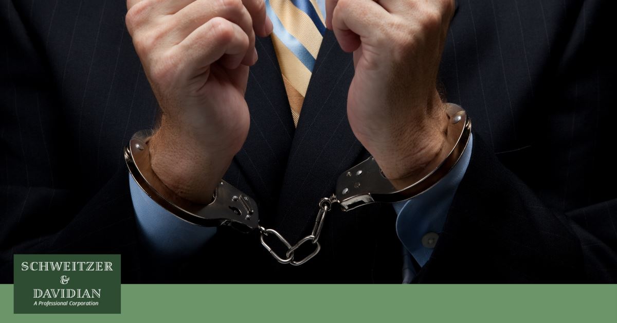 man in suit and tie with handcuffed hands